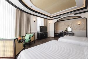 a hotel room with two beds and a television at Can Gio Park Hotel in Cần Giờ