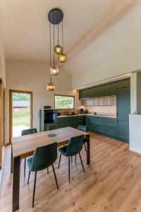 a kitchen with a wooden table and green cabinets at Auszeitquartier in Biedenkopf