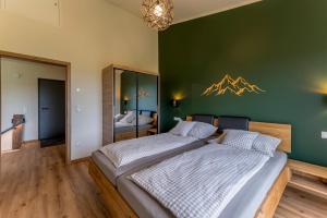 a bedroom with two beds and a green wall at Auszeitquartier in Biedenkopf