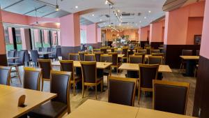 a restaurant with tables and chairs and pink walls at hotel VERDE in Arao