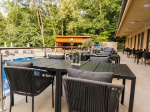 a patio with tables and chairs and a pool at The Hotel Unforgettable - Hotel Tiliana by Homoky Hotels & Spa in Budapest