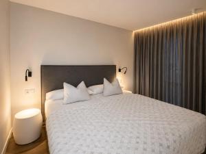a bedroom with a large bed with white sheets and pillows at Apartaments Turístics Conseller in Andorra la Vella +38 photos