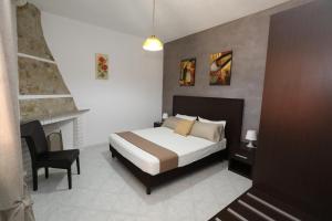 a bedroom with a bed and a desk and a chair at Helios Rooms in Quartu SantʼElena