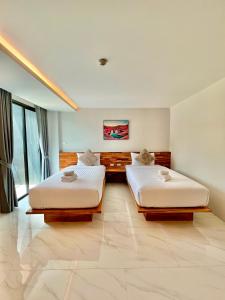 two beds in a hotel room with two bedsvisor at Ozone hotel khanom in Ban Phang Phrao