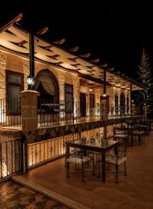 a building with tables and chairs on a patio at night at Sakli Cave House in Avanos