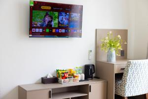 a living room with a tv on the wall at TH Luxury Hotel 2 in Phú Quốc +9 photos