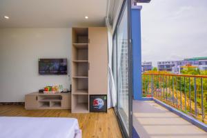 a bedroom with a balcony with a view of a city at TH Luxury Hotel 2 in Phú Quốc