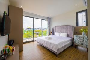 a bedroom with a bed and a large window at TH Luxury Hotel 2 in Phú Quốc