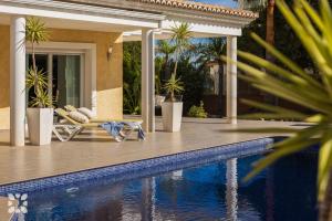 a house with a swimming pool next to a house at Villa Esplendida by Abahana Villas in Ifach