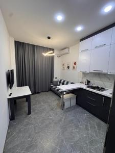 a kitchen with white cabinets and a couch in a room at Panorama in Sumqayıt