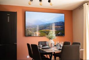 a dining room with a table and a large picture on the wall at Azure méditerranée in Sérignan