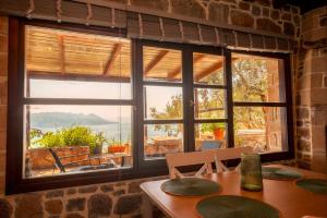 a room with a table and a window with a view at Helios stone house in Aegina