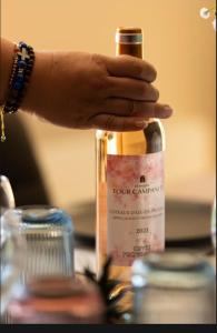 a person holding a bottle of wine on a table at Azure méditerranée in Sérignan