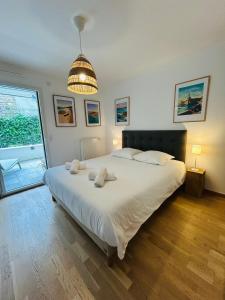 a bedroom with a large bed and a large window at L'Hermine terrasse et parking, 500 plage in Concarneau