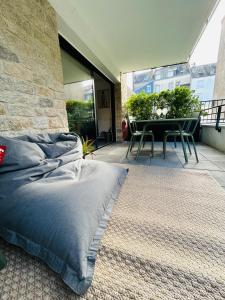 a bedroom with a bed and a table on a balcony at L'Hermine terrasse et parking, 500 plage in Concarneau