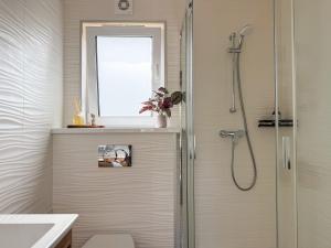 a shower with a glass door in a bathroom at FewoCrew Devils Cabin Premium Tiny House nahe Teufelsmauer in Wienrode +19 photos