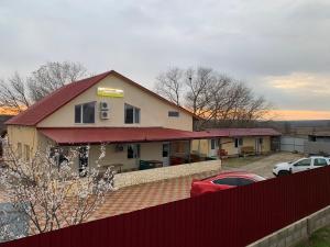 a building with a red roof in a parking lot at Comfort in Reni