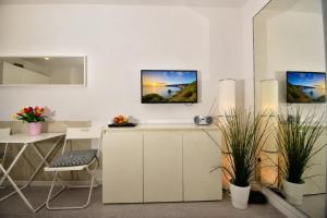 a kitchen with white cabinets and a table with plants at Kirchenplatz 6 Apartment 18 Atlantic in Warnemünde