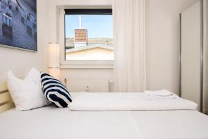 a bedroom with two beds and a window at Kirchenplatz 6 Apartment 18 Atlantic in Warnemünde