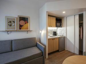 a living room with a couch and a kitchen at Aparthotel Adagio Access Paris La Villette in Paris