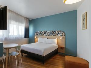a hotel room with a bed and a table at Aparthotel Adagio Access Paris La Villette in Paris