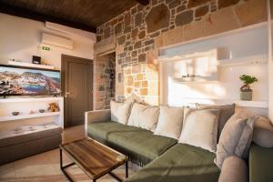 a living room with a couch and a brick wall at Helios stone house in Aegina