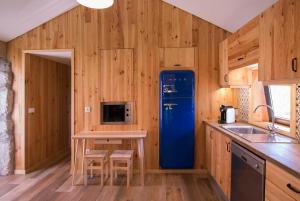 a kitchen with wooden walls and a blue refrigerator at Welcome to Gerês in Ventosa