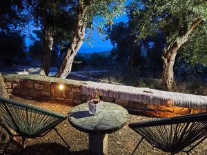 a table and two chairs sitting next to a stone wall at Casa Tereza in Plátanos +60 photos