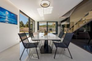 a dining room with a white table and chairs at Villas Weiss in Vir