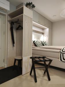 a bedroom with a bed and a table and a stool at Arte Güldenstubbe Residences in Kuressaare