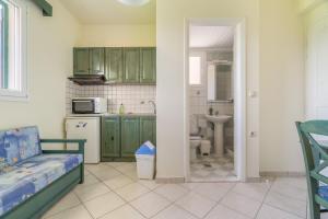a kitchen with green cabinets and a bed in a room at Odysseia Beachside Apartments in Nikiana +91 photos