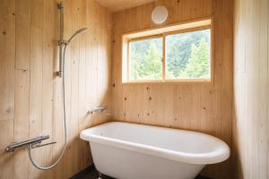 a bathroom with a bath tub and a window at 三ツ峠の宿 in Nishikatsuracho