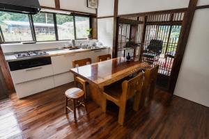 a kitchen with a wooden table and some chairs at 三ツ峠の宿 in Nishikatsuracho