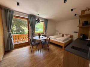 a living room with a bed and a table with chairs at Appartementhaus Grocke in Wagrain