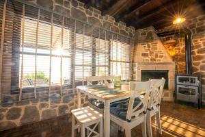 a dining room with a table and chairs and a stone fireplace at Helios stone house in Aegina