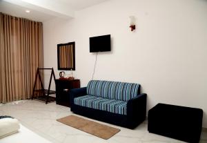 a living room with a couch and a television at Ever Breeze Ella Hotel in Ella