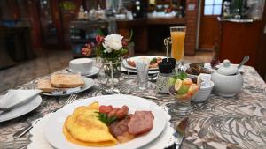 a table topped with plates of breakfast foods and drinks at Lamor Guest House in Middelburg