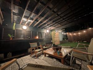 a patio with a table and chairs and a fire pit at 民泊やがみ-Yagami- in Sanagu