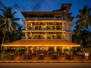 a building with tables and chairs in front of it at Goa Villagio Hideaway in Majorda