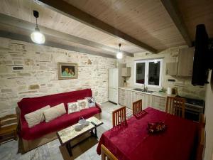 a living room with a red couch and a table at Mersini Village in Milonianá +18 photos