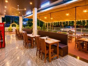 a restaurant with wooden tables and chairs in a restaurant at Goa Villagio Hideaway in Majorda