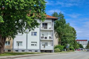 a white apartment building on the side of a street at Goldenfields apartment in Kranj