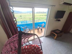 a bedroom with a bed and a sliding glass door at mythriinn in Araku +3 photos