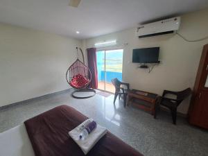 a bedroom with a bed and a room with a television at mythriinn in Araku