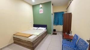 a bedroom with a bed and two blue chairs at Gravity Groups Core VHR Residency in Puducherry Airpoert