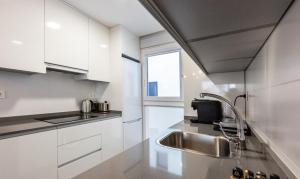 a kitchen with white cabinets and a sink and a window at LM APARTAMENTOS Aguacate 5 in El Varadero