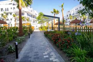 a walkway in front of a building with flowers at LM APARTAMENTOS Aguacate 5 in El Varadero