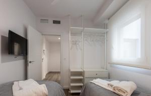 a bedroom with white walls and a bed with towels at LM APARTAMENTOS Aguacate 5 in El Varadero +11 photos