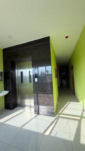 a hallway of a building with a door and green walls at Gravity Groups Core VHR Residency in Puducherry Airpoert