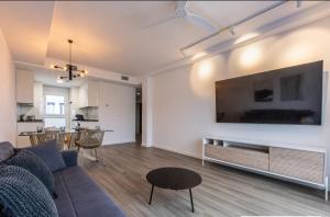 a living room with a couch and a tv on a wall at LM APARTAMENTOS Aguacate 5 in El Varadero